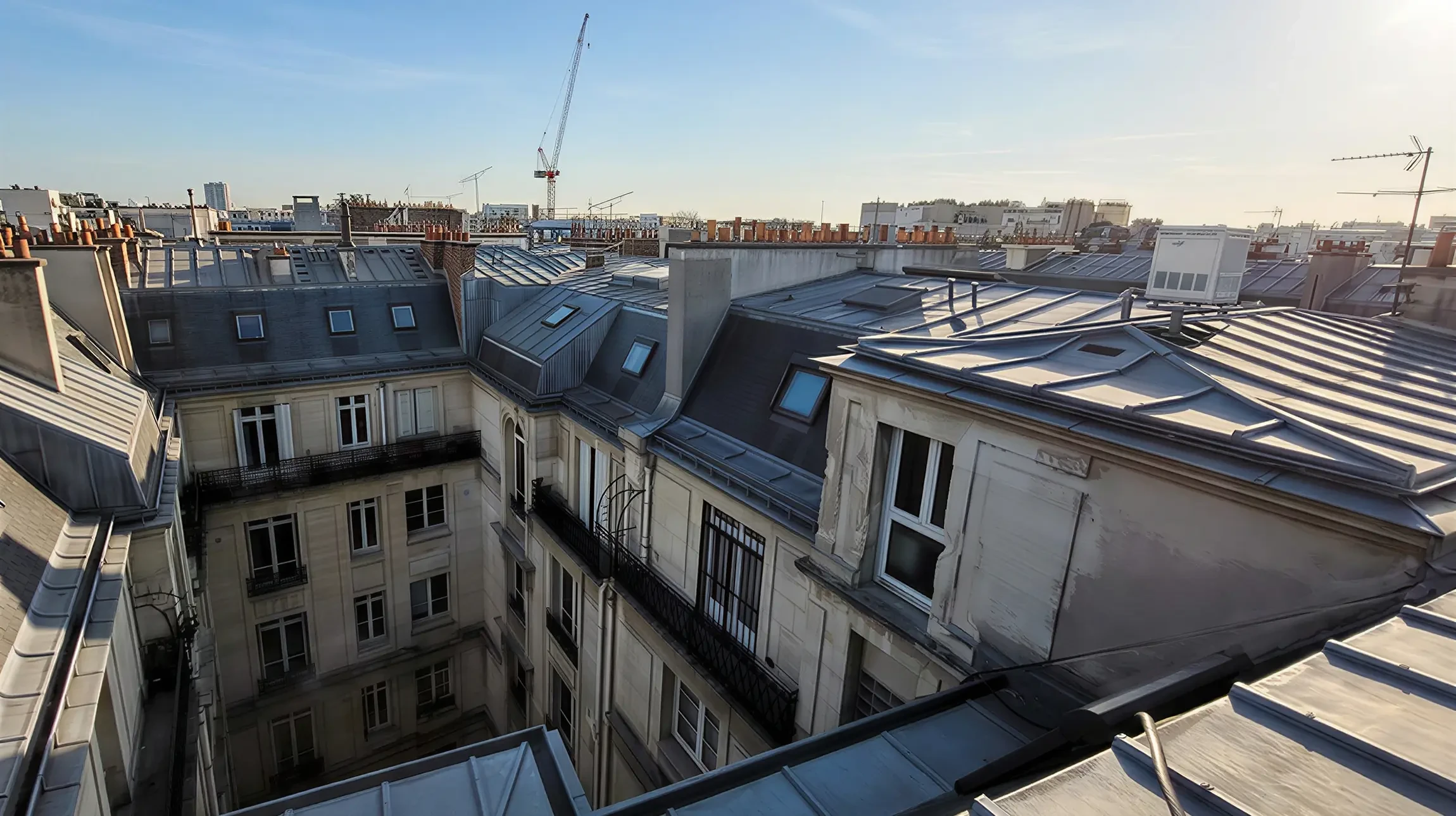 Ouvrier en équipement de sécurité effectuant des travaux d'accès par corde sur structure métallique en hauteur, environnement industriel extérieur avec échafaudages visibles en arrière-plan